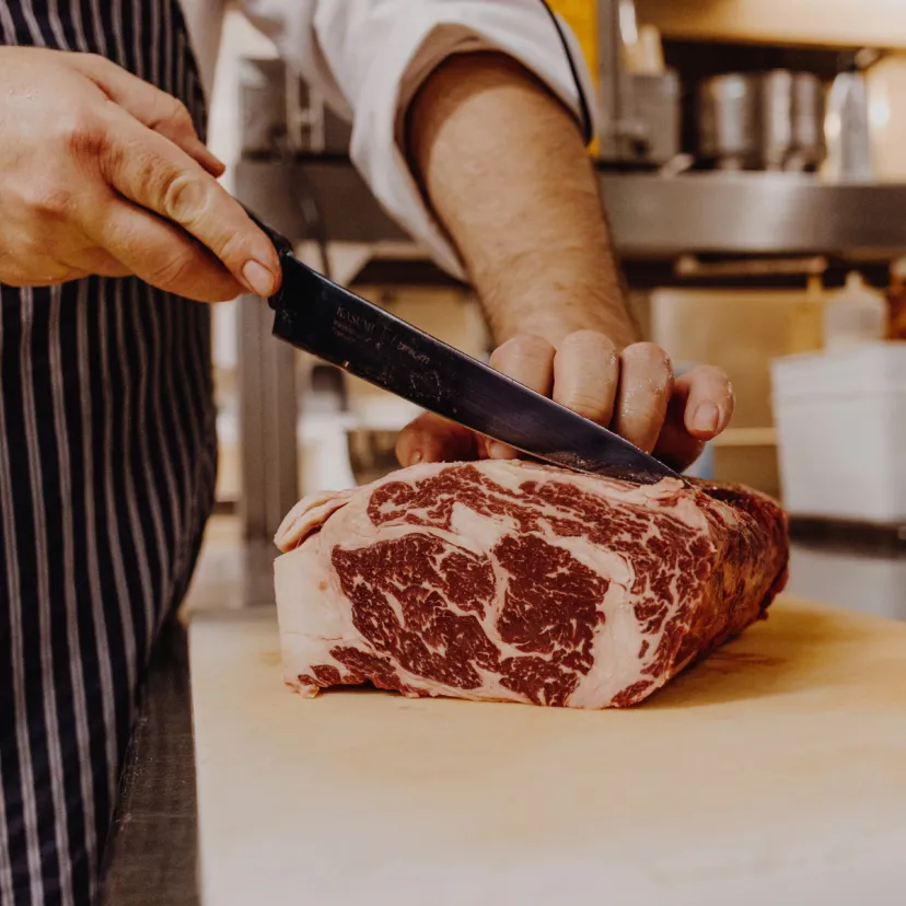 Butcherei Prime Grill Keitum: Messer schneidet Stück Fleisch