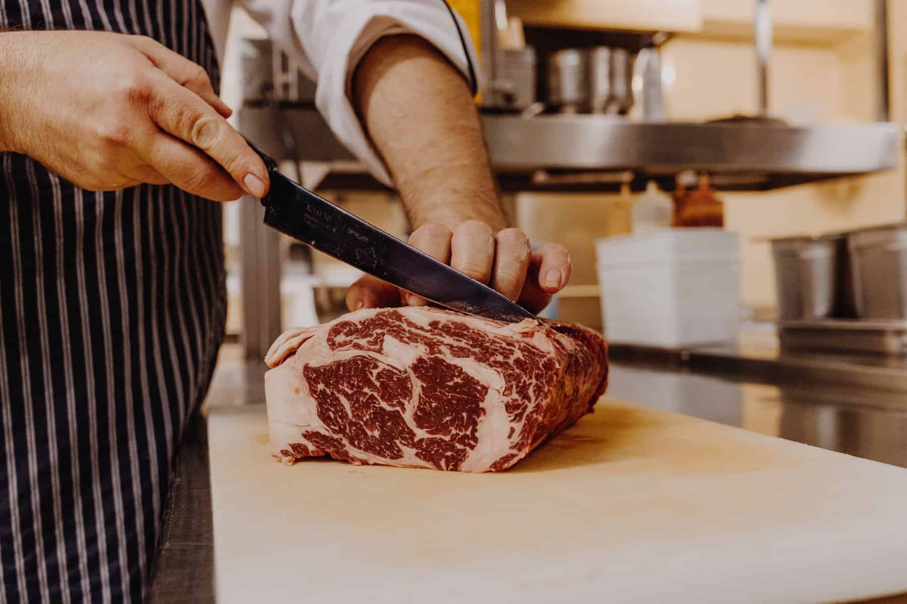 Butcherei Prime Grill Keitum: Messer schneidet Stück Fleisch