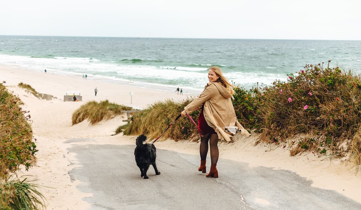 Finja geht mit einem schwaren Hund an den Strand
