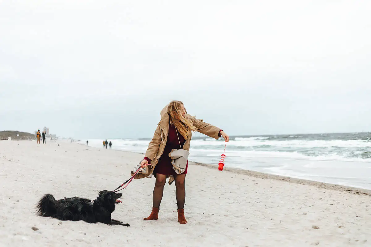 Finja spielt mit Hund am Strand